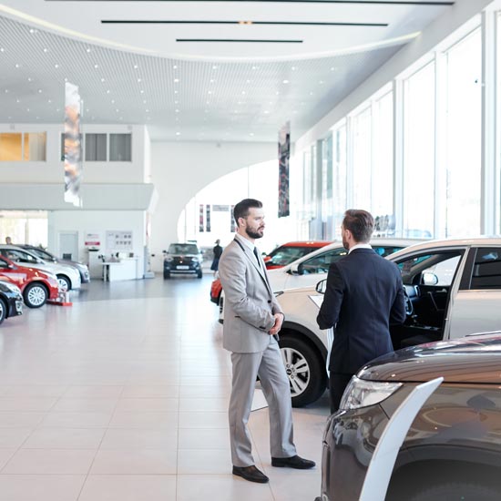 Two auto salesmen on showroom floor
